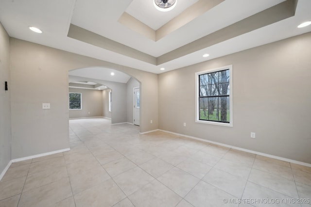 15338 S Brewster Rd, Mounds, OK 74047 - unfurnished room featuring arched walkways, light tile patterned floors, baseboards, a raised ceiling, and recessed lighting