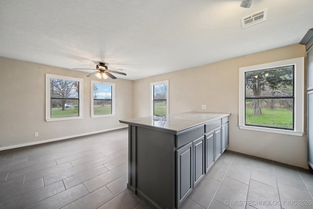 15338 S Brewster Rd, Mounds, OK 74047 - kitchen featuring ceiling fan, light countertops, a peninsula, light tile patterned floors, and visible vents