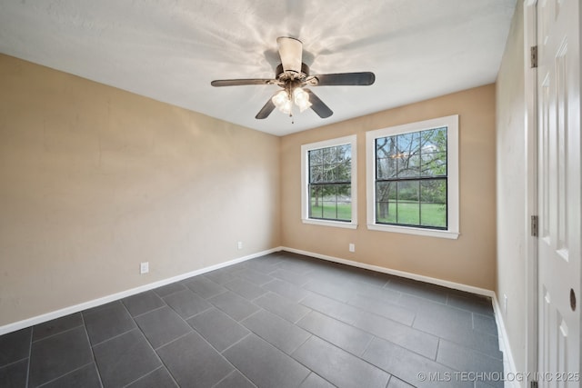 15338 S Brewster Rd, Mounds, OK 74047 - unfurnished room with baseboards, a ceiling fan, and dark tile patterned floors