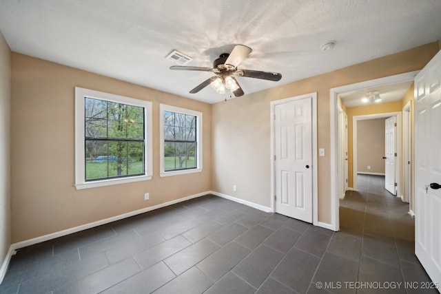 15338 S Brewster Rd, Mounds, OK 74047 - unfurnished bedroom with visible vents, a ceiling fan, baseboards, and dark tile patterned flooring