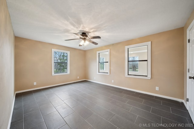 15338 S Brewster Rd, Mounds, OK 74047 - empty room with baseboards, dark tile patterned floors, and ceiling fan