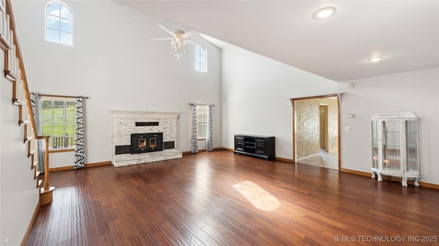 unfurnished living room featuring a healthy amount of sunlight, wood finished floors, a ceiling fan, and stairway