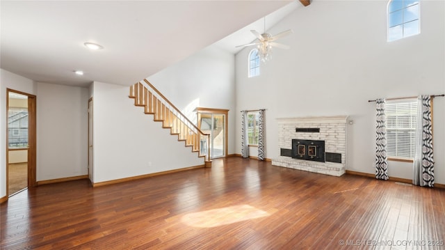unfurnished living room with wood-type flooring, baseboards, a ceiling fan, and stairway