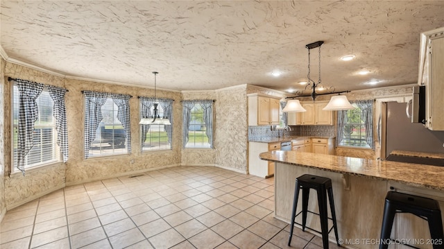 kitchen featuring a peninsula, a textured ceiling, ornamental molding, a breakfast bar, and light tile patterned flooring