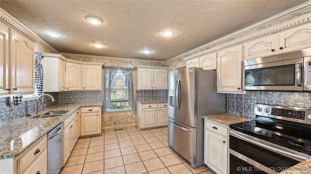 kitchen featuring a sink, light tile patterned floors, appliances with stainless steel finishes, and a textured ceiling