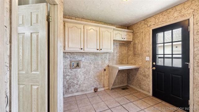 clothes washing area featuring light tile patterned flooring, a textured ceiling, washer hookup, and baseboards