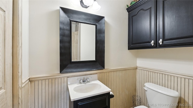 bathroom with vanity, wainscoting, and toilet