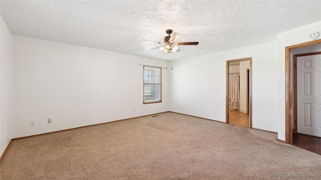 unfurnished room featuring carpet flooring, a textured ceiling, baseboards, and ceiling fan