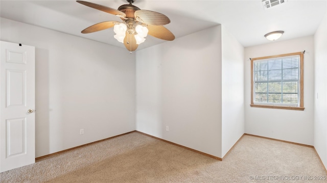 empty room featuring visible vents, baseboards, a ceiling fan, and light carpet