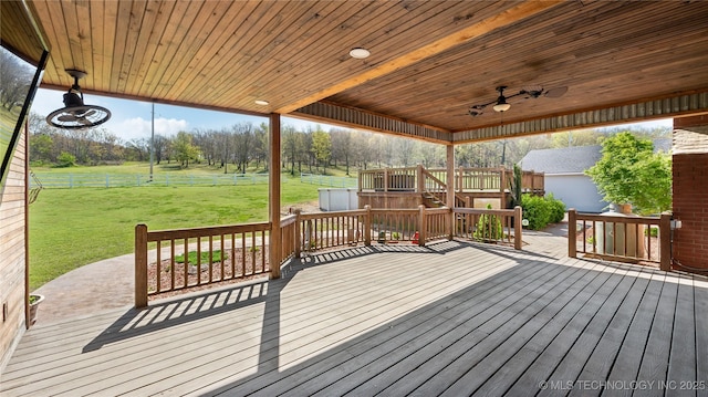wooden terrace with a yard, ceiling fan, and fence