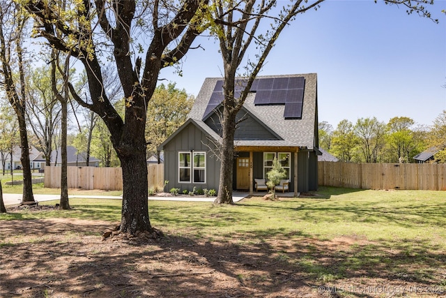 440 W 2nd St, Silo, OK 74701 - view of front of house featuring roof with shingles, roof mounted solar panels, fence, and a front lawn