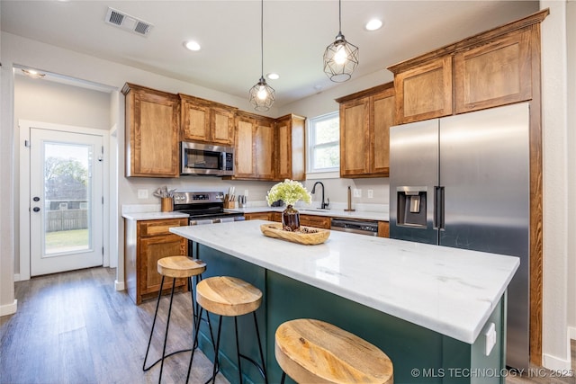 440 W 2nd St, Silo, OK 74701 - kitchen featuring visible vents, wood finished floors, light countertops, stainless steel appliances, and brown cabinets