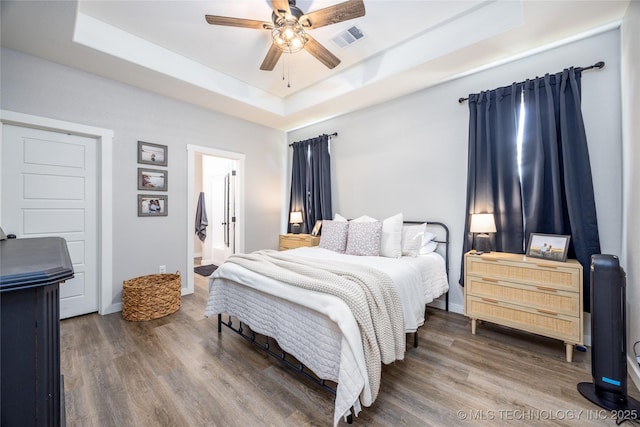 440 W 2nd St, Silo, OK 74701 - bedroom featuring baseboards, a raised ceiling, visible vents, ceiling fan, and wood finished floors