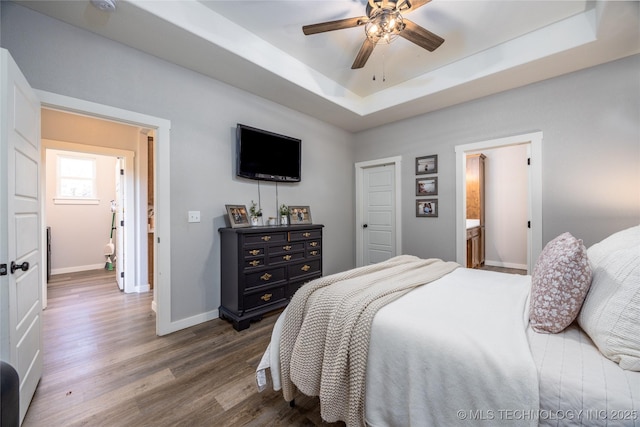 440 W 2nd St, Silo, OK 74701 - bedroom featuring dark wood-type flooring, baseboards, a ceiling fan, and a raised ceiling