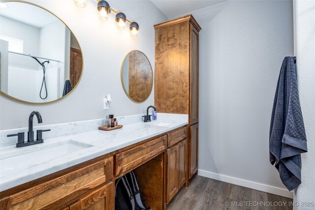 440 W 2nd St, Silo, OK 74701 - full bathroom with a sink, baseboards, double vanity, and wood finished floors