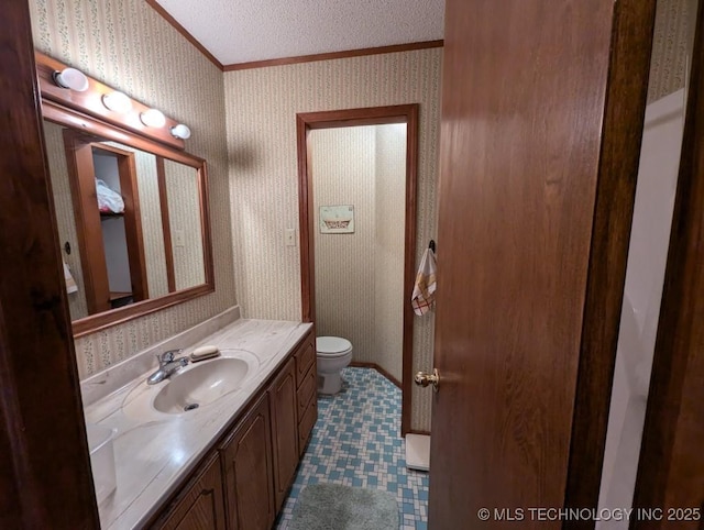 bathroom featuring wallpapered walls, vanity, crown molding, and toilet