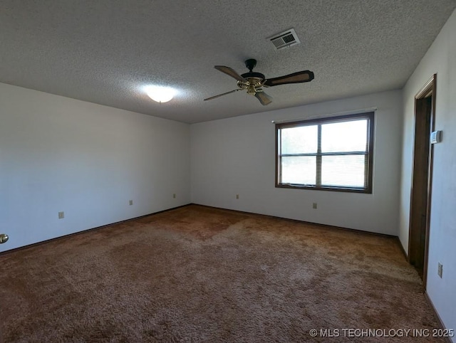 spare room with visible vents, ceiling fan, carpet floors, and a textured ceiling