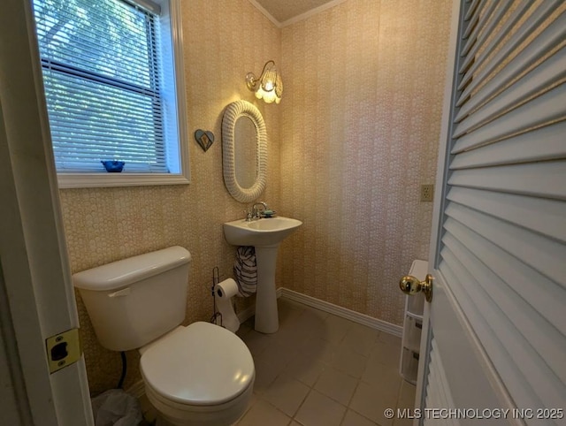 half bathroom featuring toilet, plenty of natural light, baseboards, and wallpapered walls