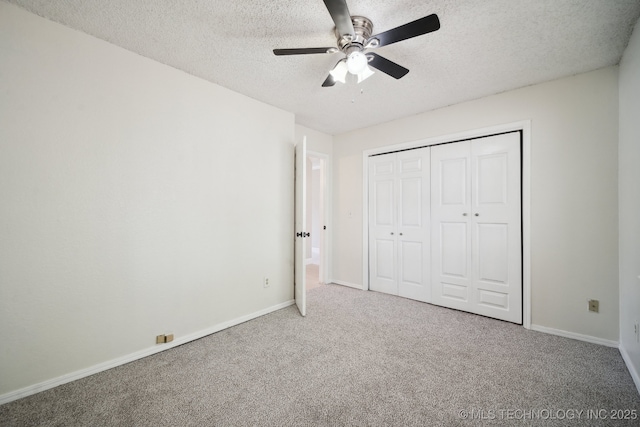 unfurnished bedroom featuring a textured ceiling, a closet, carpet flooring, and baseboards