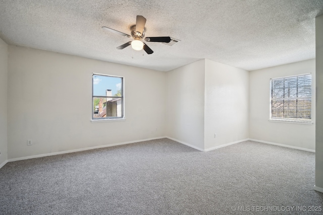 carpeted empty room featuring a textured ceiling, ceiling fan, visible vents, and baseboards