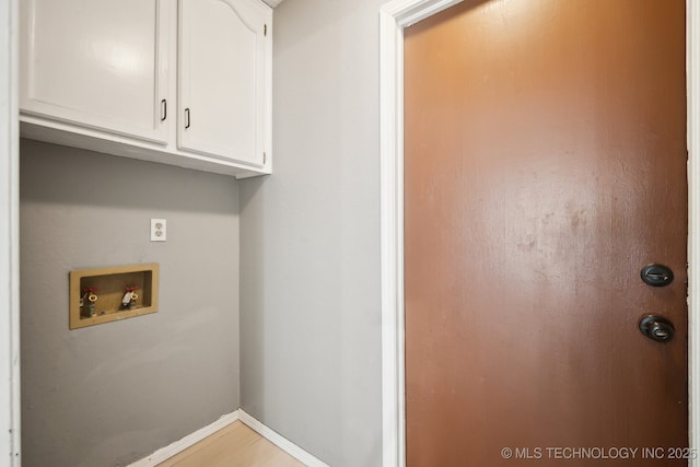 laundry area with hookup for a washing machine, cabinet space, and baseboards