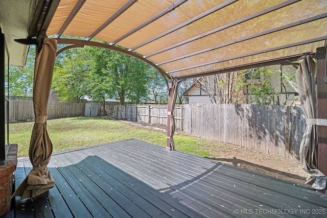 wooden terrace featuring a yard, a pergola, and a fenced backyard