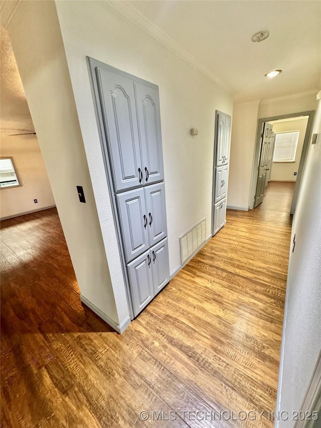 5101 S Spruce Dr, Sand Springs, OK 74063 - hallway with crown molding, visible vents, baseboards, and light wood-type flooring