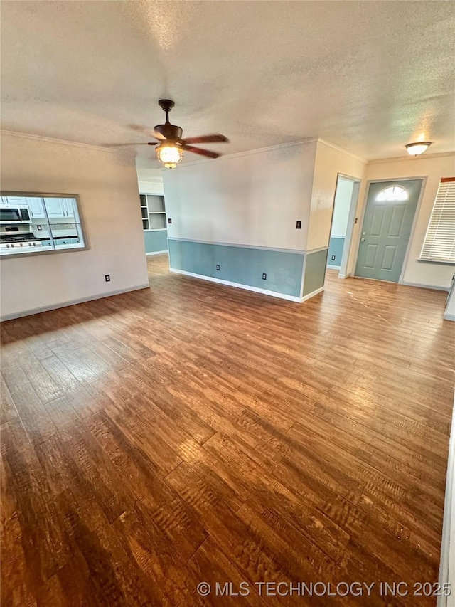 5101 S Spruce Dr, Sand Springs, OK 74063 - unfurnished living room featuring baseboards, ceiling fan, a textured ceiling, crown molding, and wood finished floors