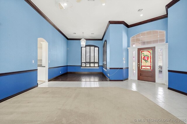11746 Giorgio Dr, Skiatook, OK 74070 - entrance foyer with visible vents, baseboards, arched walkways, ornamental molding, and tile patterned flooring