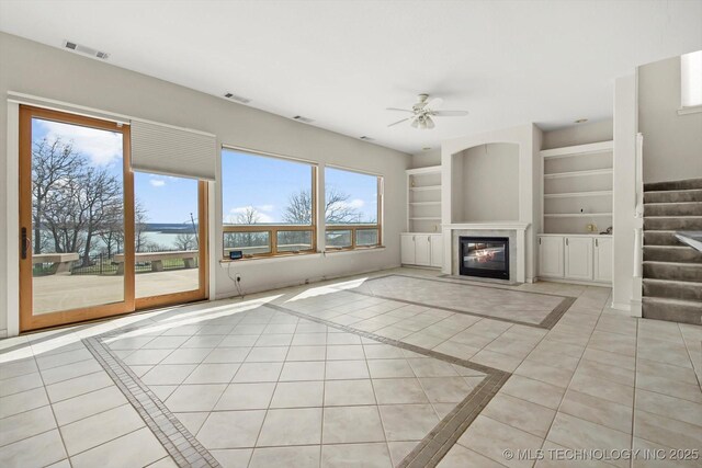 11746 Giorgio Dr, Skiatook, OK 74070 - unfurnished living room with visible vents, a wealth of natural light, stairway, and ceiling fan