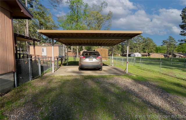 612 W Circle Dr, Broken Bow, OK 74728 - view of parking featuring fence, a detached carport, driveway, and a storage shed