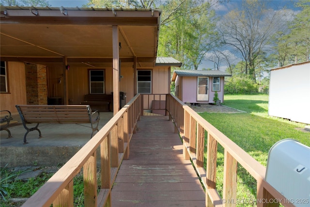 back of house with a lawn, a storage shed, an outbuilding, and metal roof