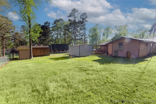 view of yard with a storage unit, an outdoor structure, and fence