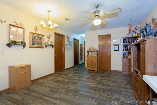 interior space featuring dark wood-style flooring, a textured ceiling, visible vents, baseboards, and an inviting chandelier
