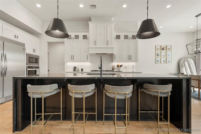 2996 E 142nd Ct S, Bixby, OK 74008 - kitchen featuring tasteful backsplash, white cabinets, visible vents, built in appliances, and a spacious island