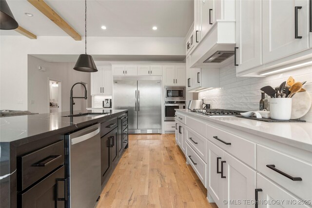 2996 E 142nd Ct S, Bixby, OK 74008 - kitchen with tasteful backsplash, white cabinetry, a sink, decorative light fixtures, and built in appliances