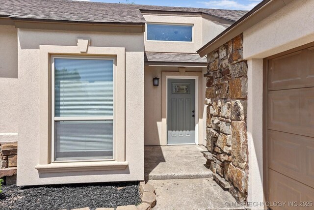 12939 E 34th St, Tulsa, OK 74134 - doorway to property featuring roof with shingles, stucco siding, and stone siding