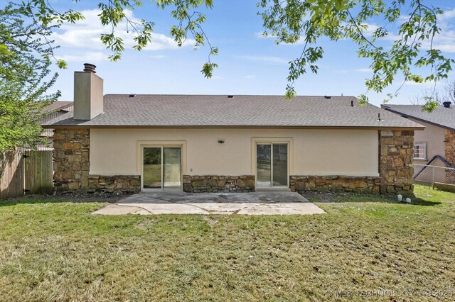 12939 E 34th St, Tulsa, OK 74134 - back of property featuring a patio, a chimney, stone siding, fence, and a lawn
