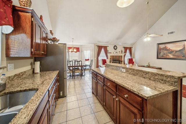 4932 W Commercial St, Broken Arrow, OK 74012 - kitchen featuring ceiling fan, a fireplace, a kitchen island, light tile patterned floors, and a sink