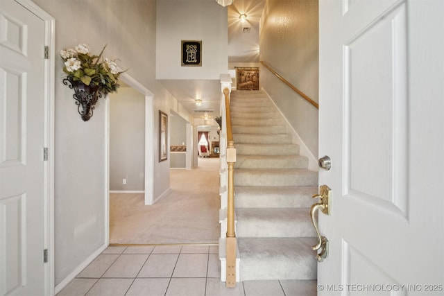 4932 W Commercial St, Broken Arrow, OK 74012 - foyer with light colored carpet, stairs, a towering ceiling, baseboards, and light tile patterned floors