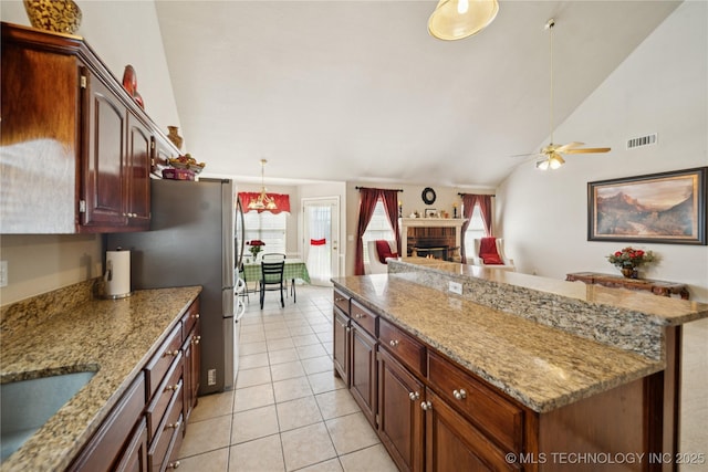 4932 W Commercial St, Broken Arrow, OK 74012 - kitchen with light tile patterned flooring, ceiling fan, a center island, a sink, and light stone counters