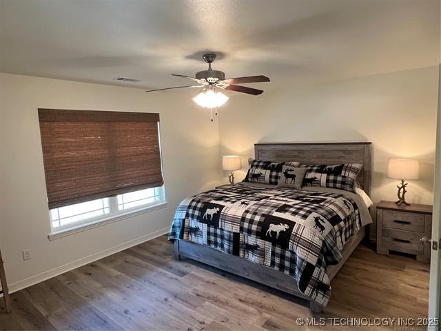 2241 231st St, Buffalo Valley, OK 74571 - bedroom with wood finished floors, ceiling fan, and baseboards
