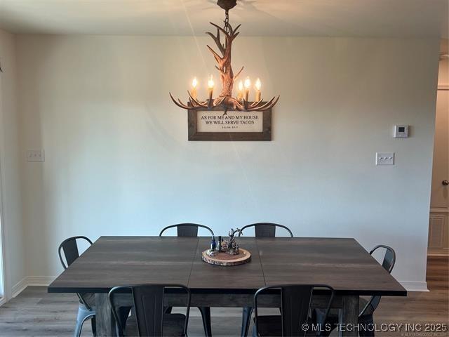 2241 231st St, Buffalo Valley, OK 74571 - dining area featuring a chandelier, wood finished floors, and baseboards