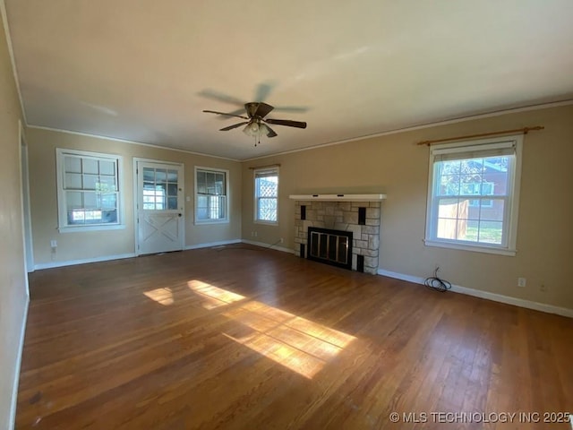 unfurnished living room featuring ceiling fan, baseboards, crown molding, and wood finished floors