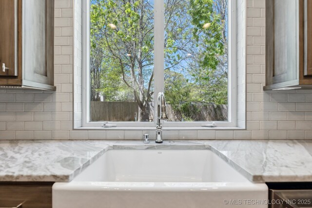 10126 S Granite Ave, Tulsa, OK 74137 - kitchen view of a sink, decorative backsplash, and light stone counters