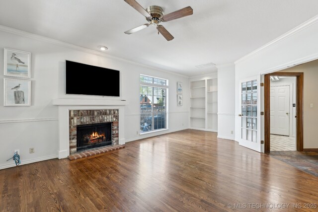 10126 S Granite Ave, Tulsa, OK 74137 - unfurnished living room with crown molding, built in features, a brick fireplace, a ceiling fan, and wood finished floors