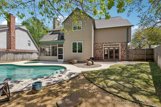10126 S Granite Ave, Tulsa, OK 74137 - back of property featuring a sunroom, a fenced backyard, a patio, brick siding, and french doors