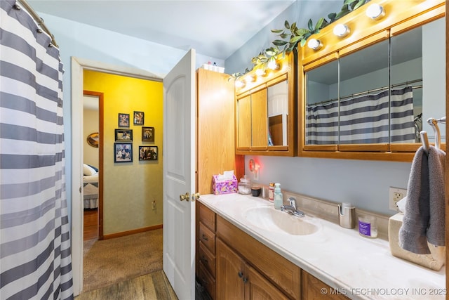 bathroom with baseboards, a shower with curtain, vanity, and wood finished floors
