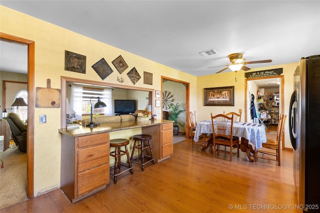 office area with visible vents, ceiling fan, and wood finished floors