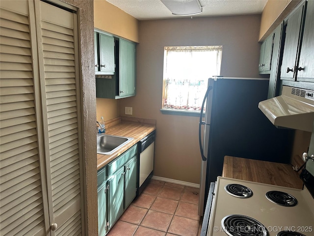 kitchen with light tile patterned floors, exhaust hood, dishwashing machine, a textured ceiling, and a sink